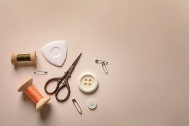 Set of tailoring accessories on light background, top view