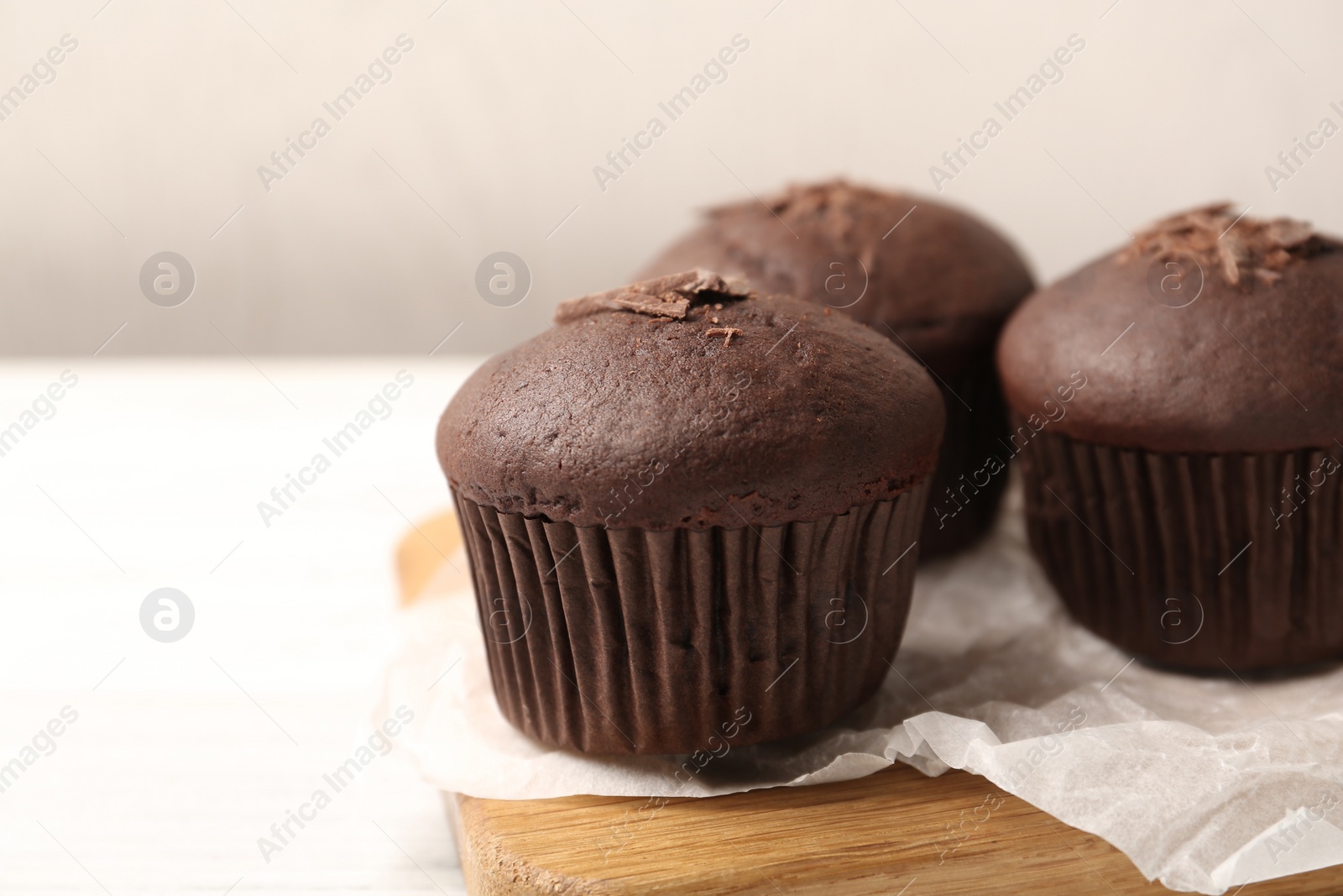 Photo of Delicious cupcakes with chocolate crumbles on white table, closeup