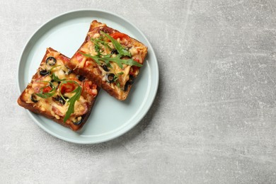 Tasty pizza toasts served on grey table, top view. Space for text