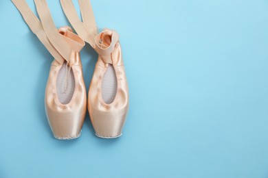 Ballet shoes. Elegant pointes on light blue background, flat lay. Space for text