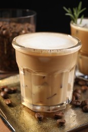 Photo of Refreshing iced coffee with milk in glass on table, closeup