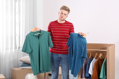 Young emotional man near wardrobe box at home