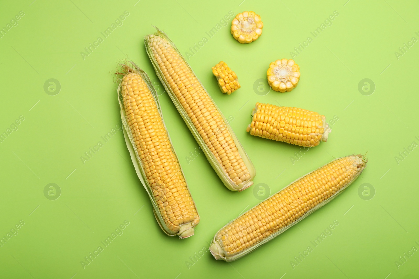 Photo of Flat lay composition with tasty sweet corn cobs on color background