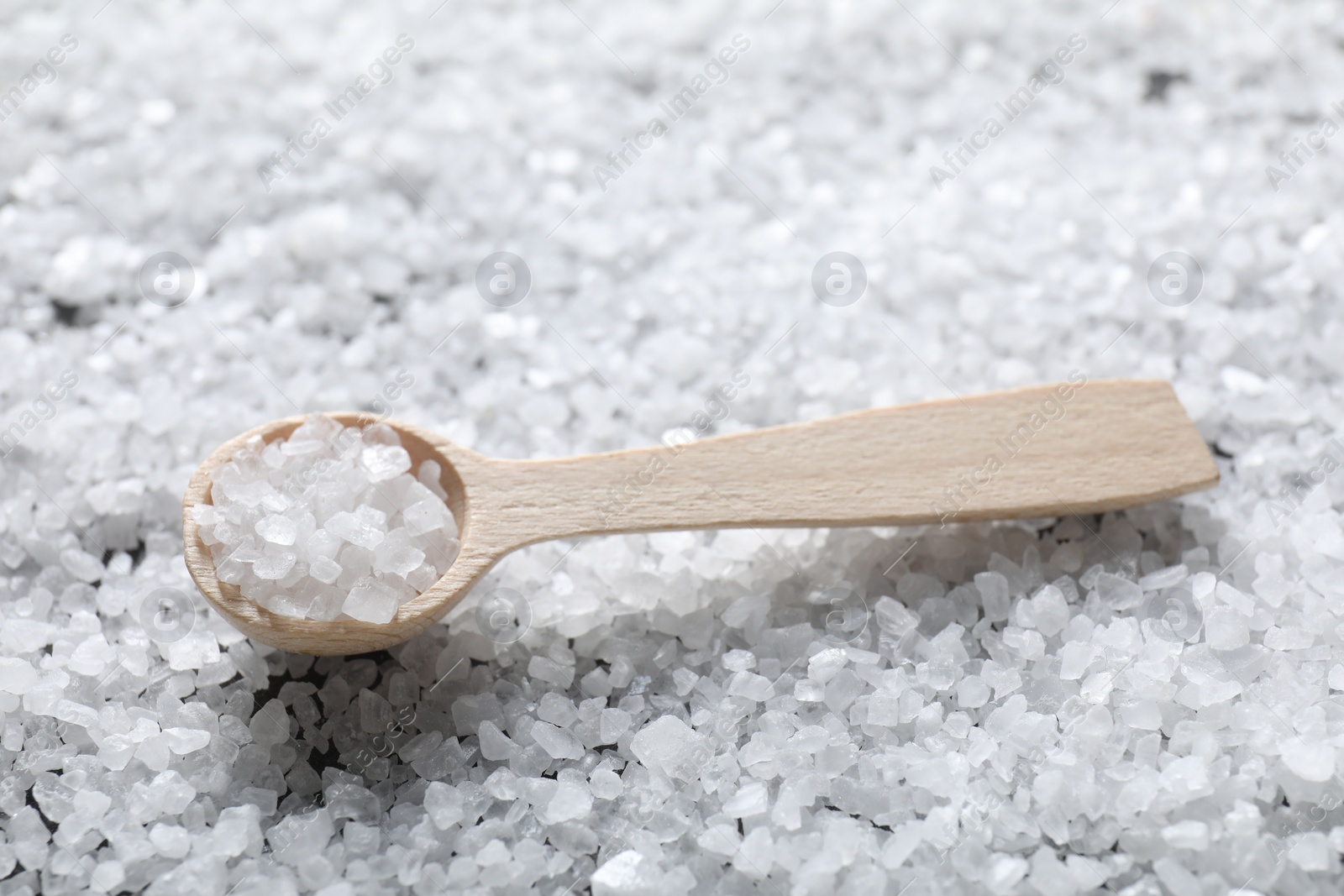 Photo of Natural salt and wooden spoon, closeup view