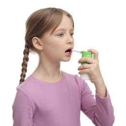 Photo of Little girl using throat spray on white background