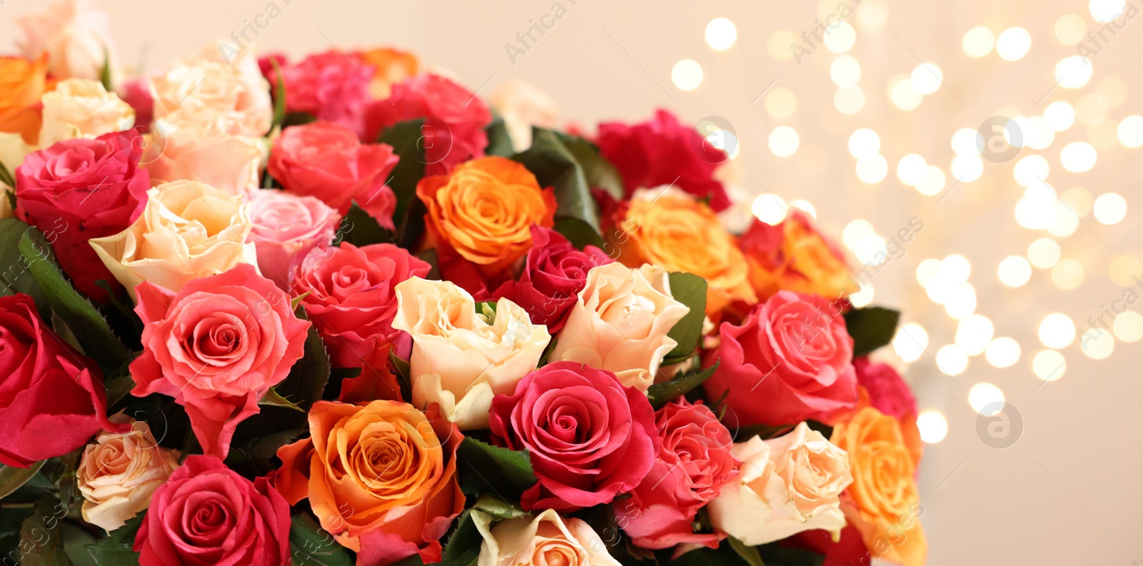 Photo of Beautiful bouquet of colorful roses on beige background, closeup