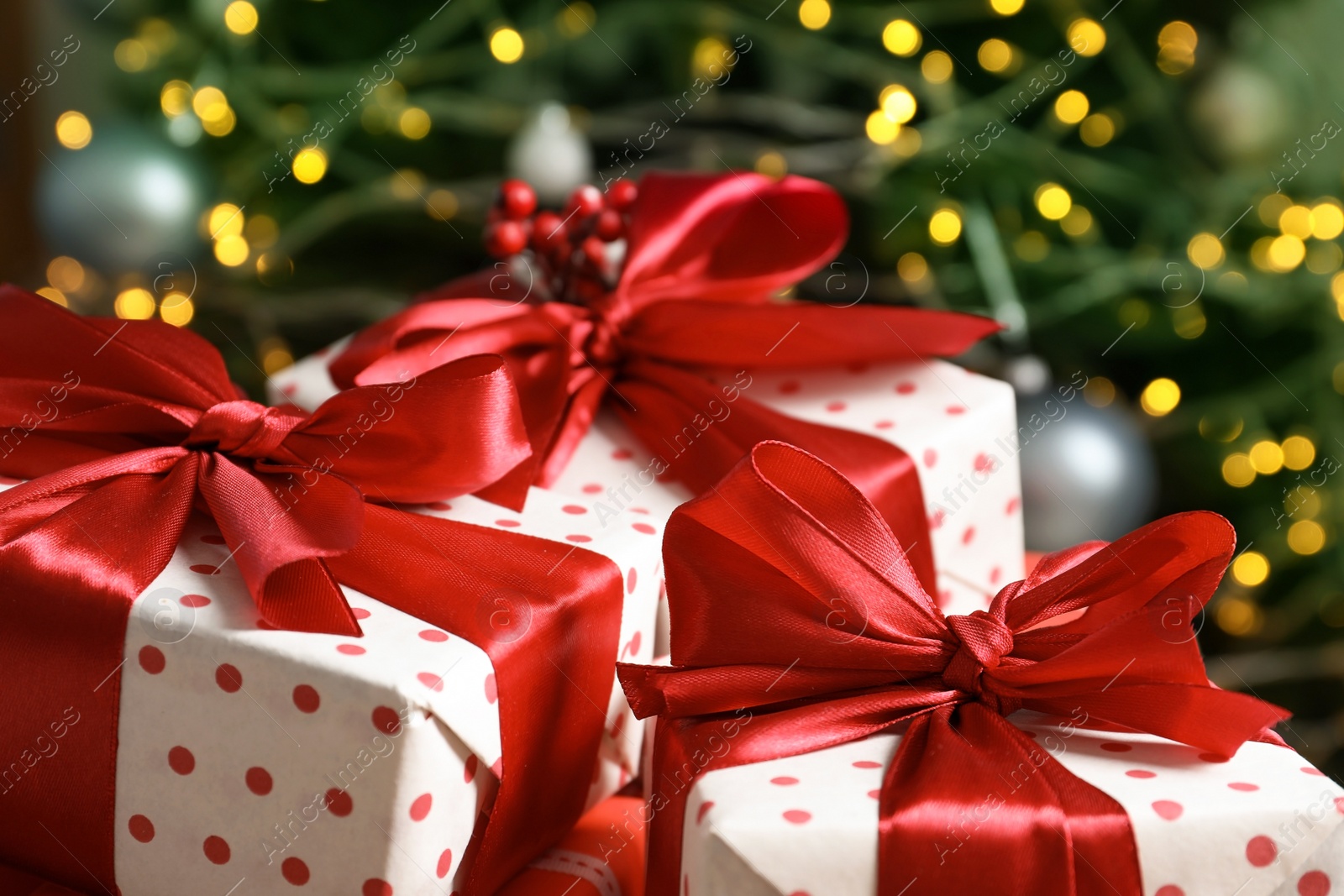 Photo of Beautiful gift boxes and blurred Christmas tree on background