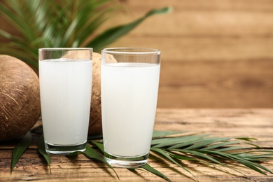 Composition with glasses of coconut water on wooden background. Space for text