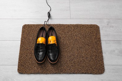 Photo of Shoes with electric dryer on rug indoors, above view