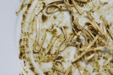 Smear of sauce and pasta on plate, top view