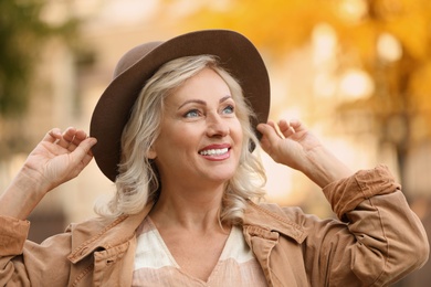 Portrait of happy mature woman with hat outdoors