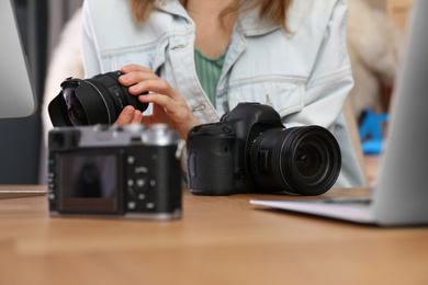 Photo of Professional photographer working at table in office, closeup