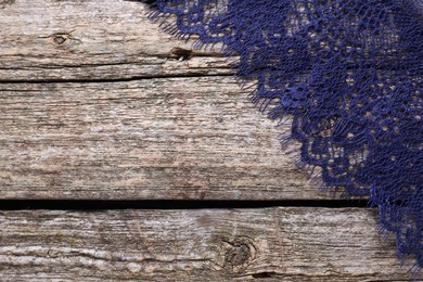 Photo of Beautiful lace on wooden table, top view. Space for text