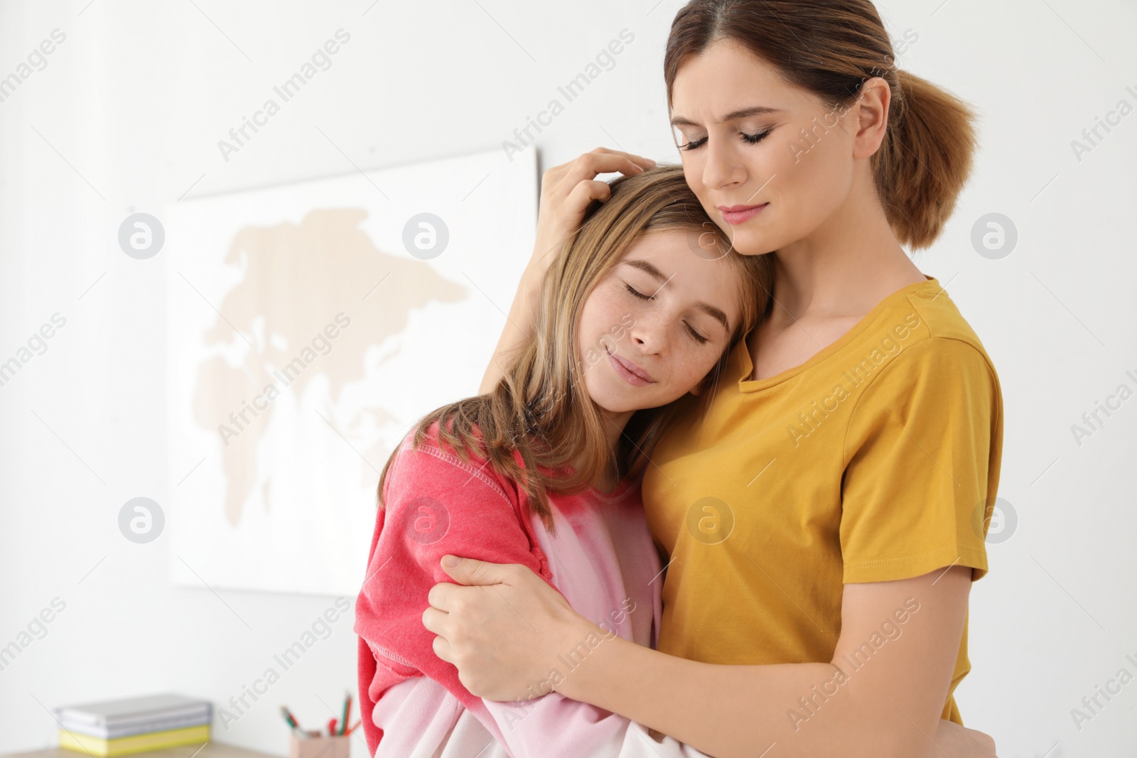 Photo of Happy mother hugging her teenager daughter at home