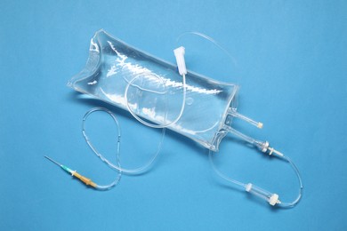 Photo of IV infusion set on light blue background, top view