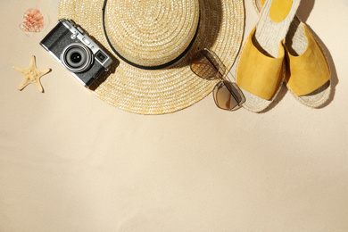 Photo of Flat lay composition with vintage camera and beach objects on sand. Space for text