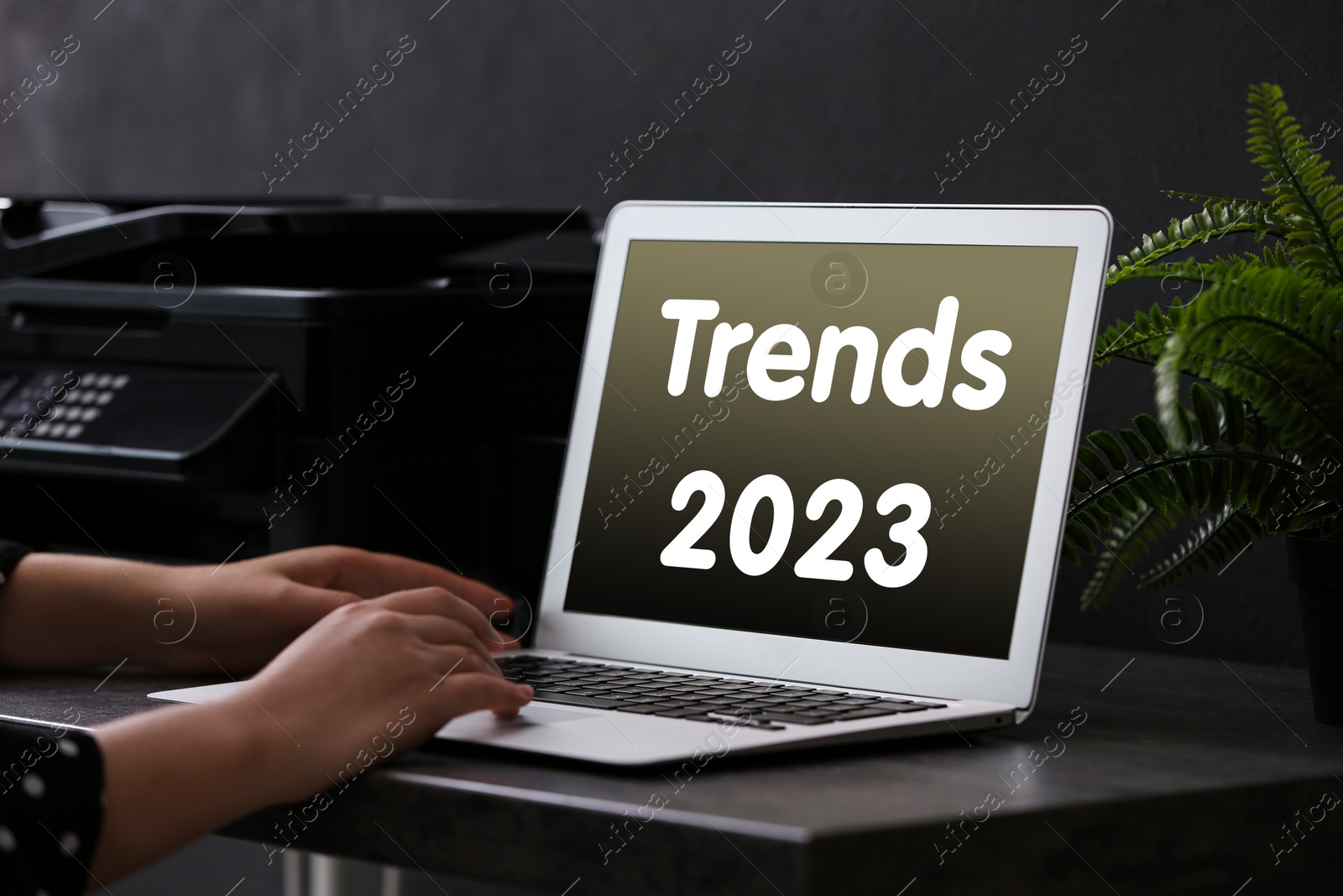 Image of Trends 2023 text on laptop display. Woman using device, closeup