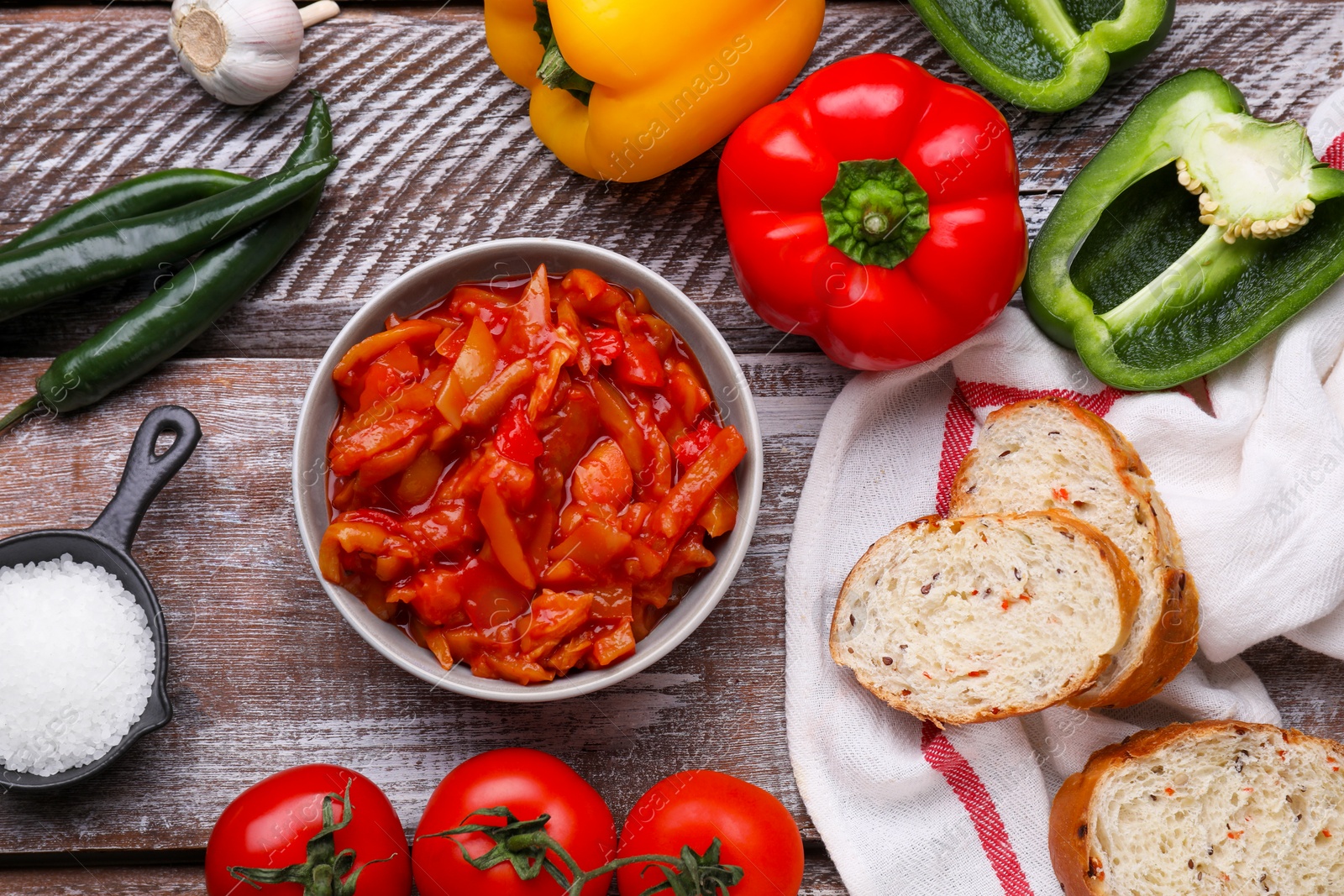 Photo of Delicious lecho and ingredients on wooden table, flat lay