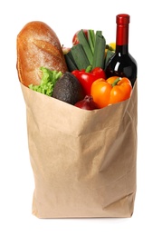 Photo of Paper bag with fresh vegetables, bread and bottle of wine on white background