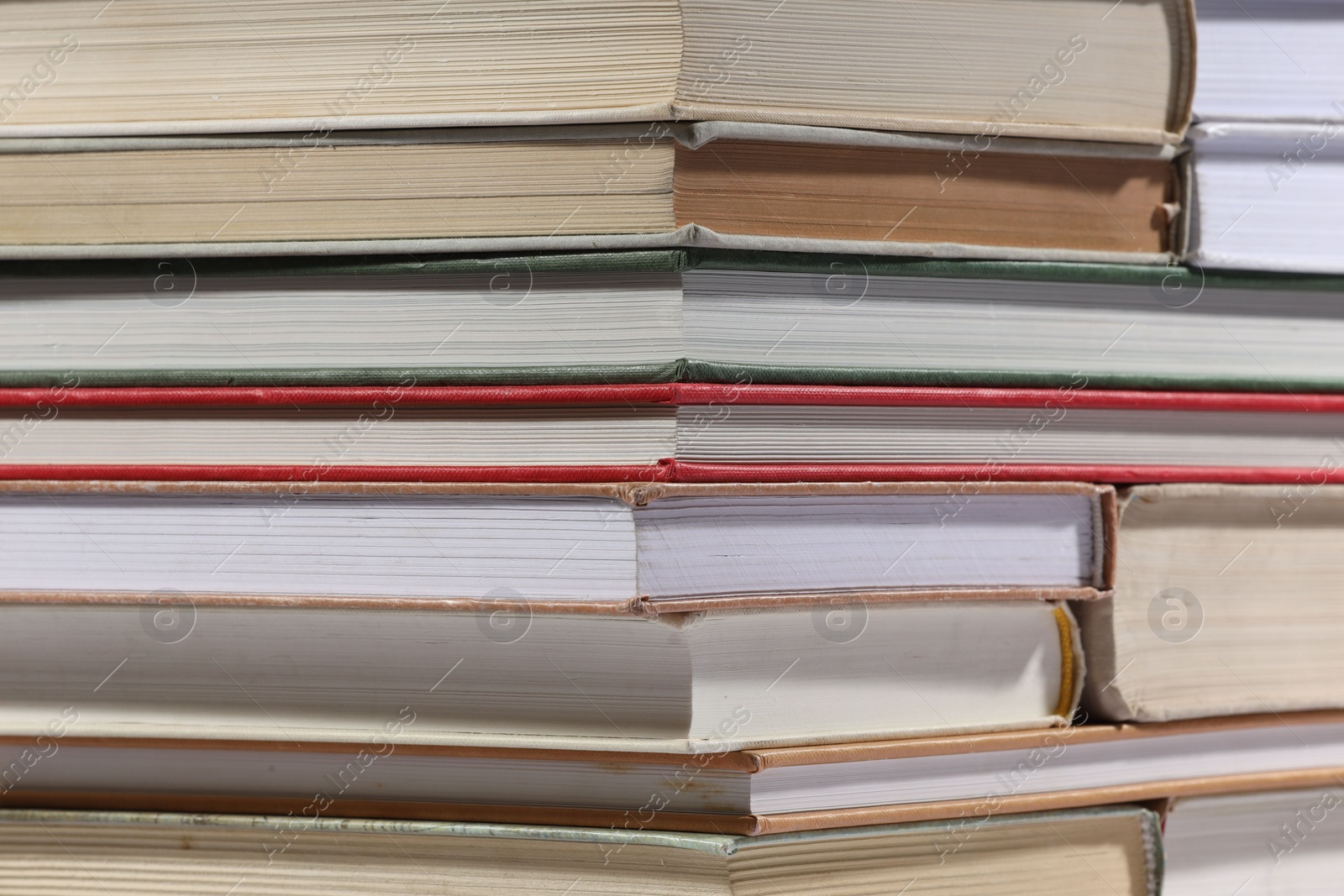 Photo of Stack of many different hardcover books as background, closeup