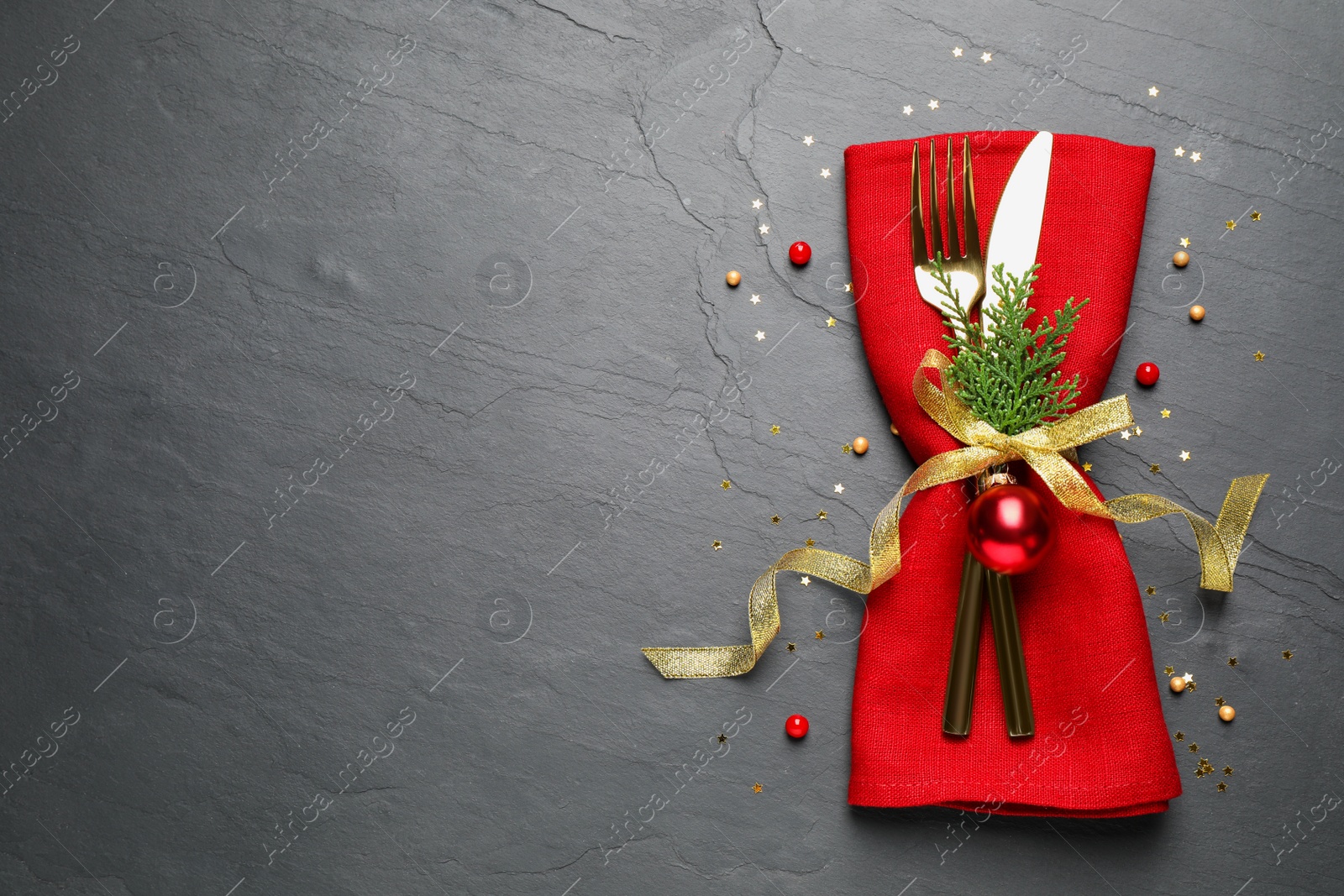 Photo of Cutlery set on grey table, top view with space for text. Christmas celebration