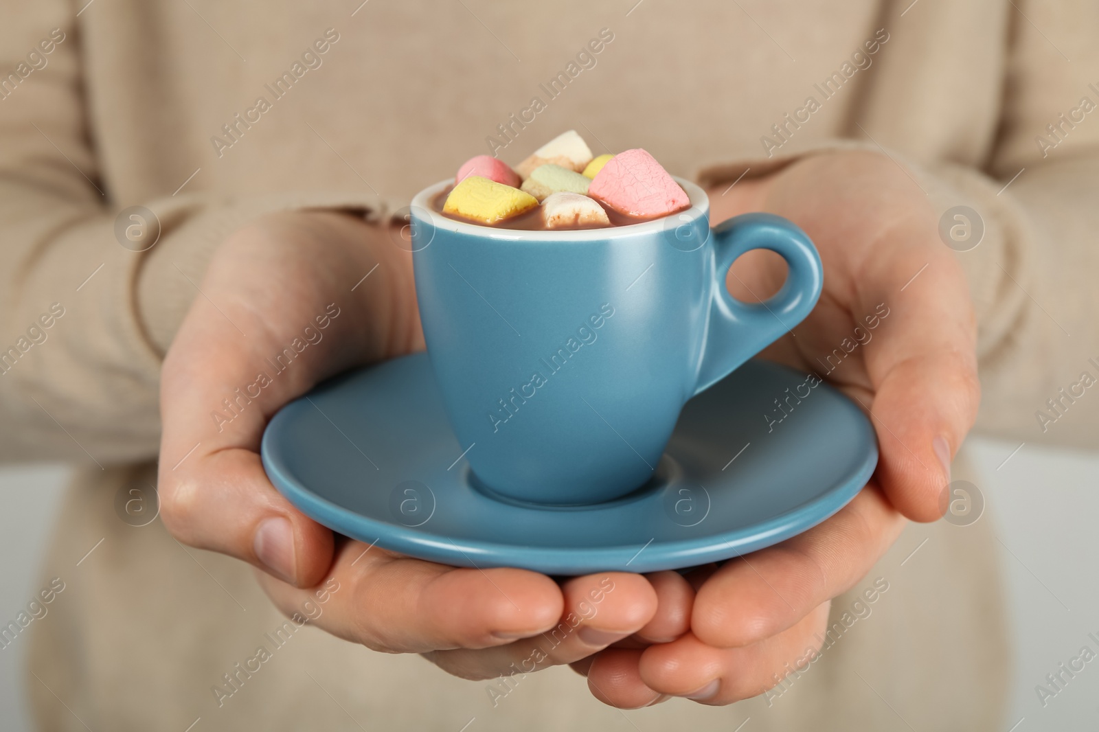 Photo of Woman holding cup of delicious hot chocolate with marshmallows, closeup