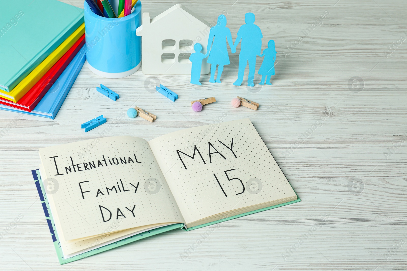 Photo of Happy Family Day. Composition with notebook and stationery on white wooden table