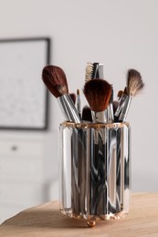 Photo of Set of professional brushes on wooden table indoors