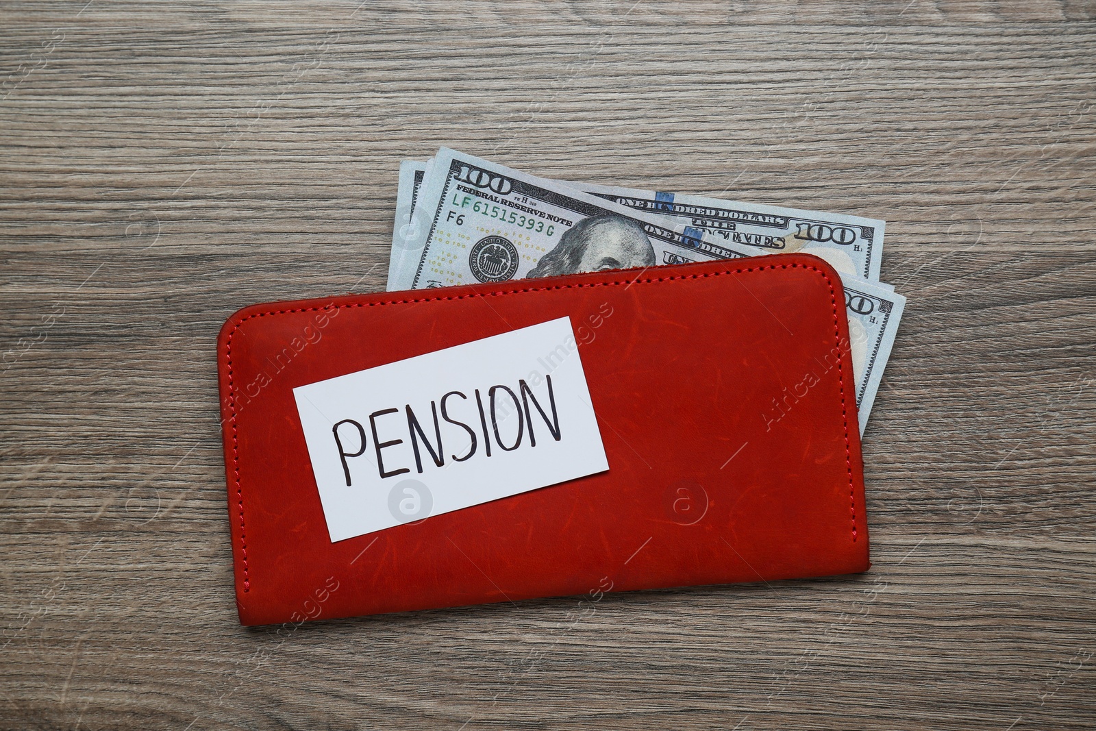 Photo of Card with word Pension, wallet and dollar banknotes on wooden table, flat lay