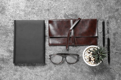 Flat lay composition with notebook and glasses on grey background