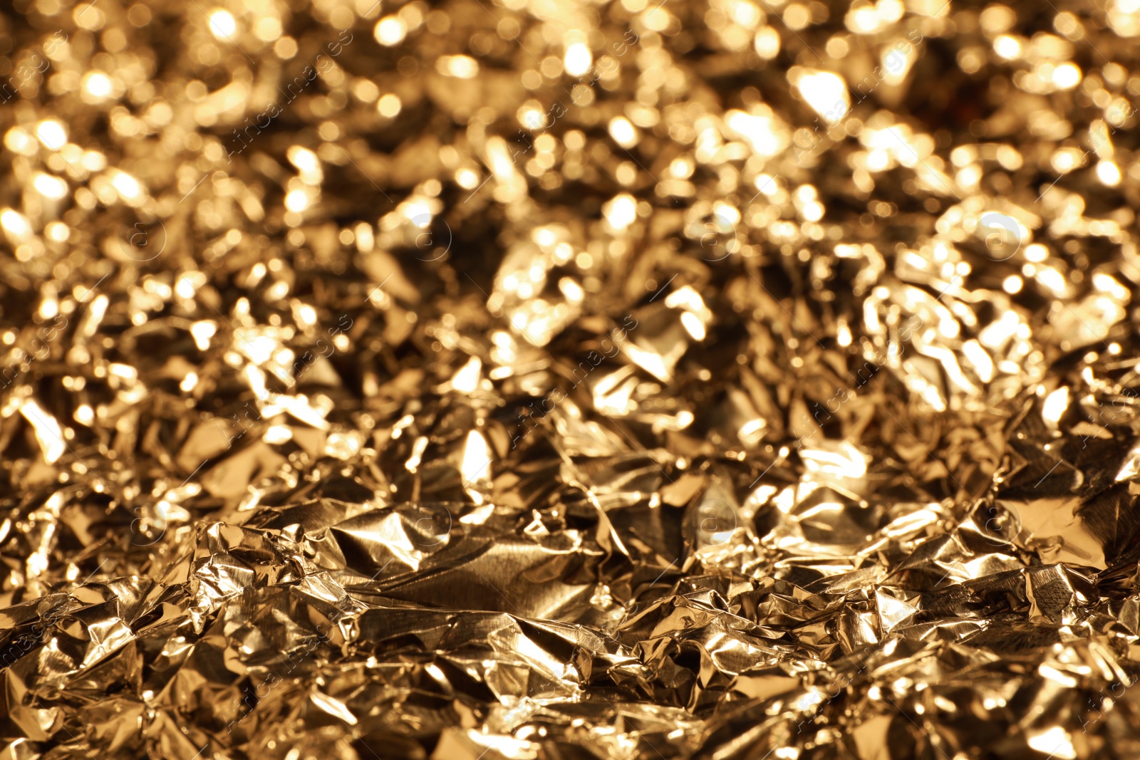 Photo of Crumpled gold foil as background, closeup view