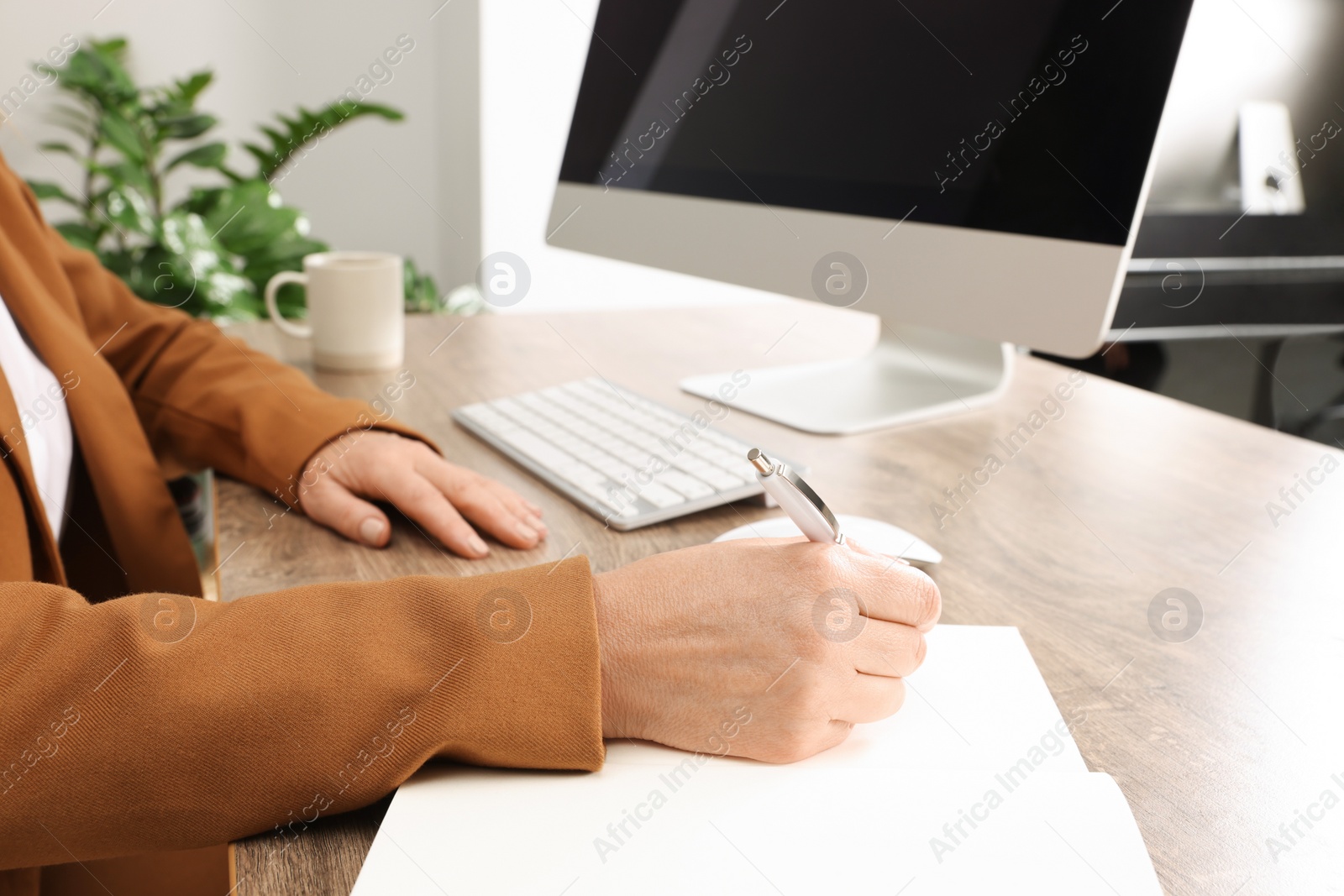 Photo of Lady boss working near computer at desk in office, closeup. Successful businesswoman