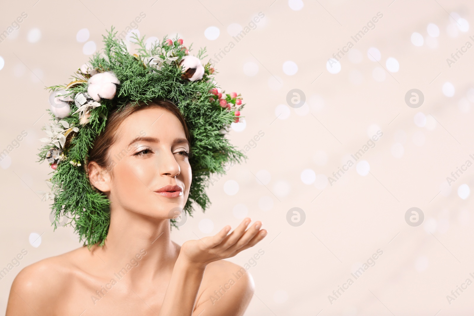 Photo of Young woman wearing wreath against blurred lights