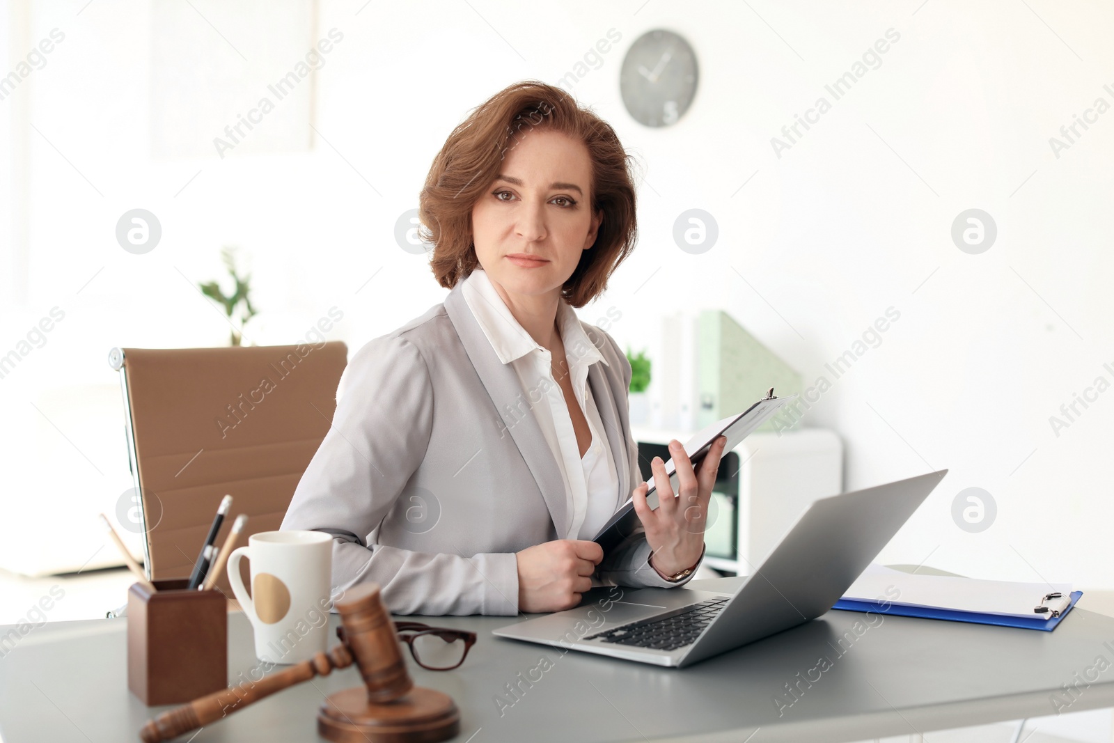 Photo of Female lawyer working with laptop at table in office