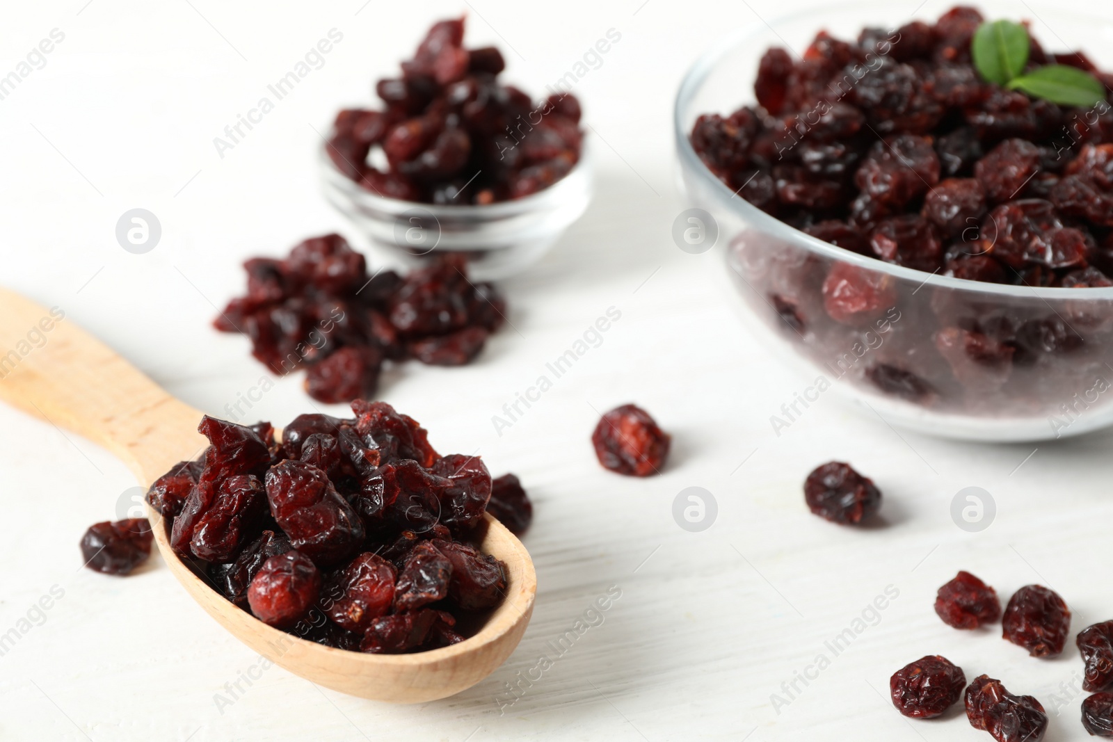 Photo of Composition with tasty dried cranberries on white wooden table