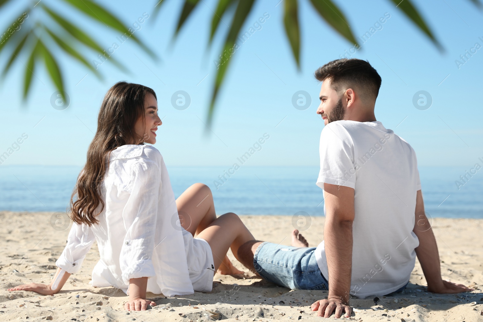 Photo of Happy young couple on beach near sea. Honeymoon trip