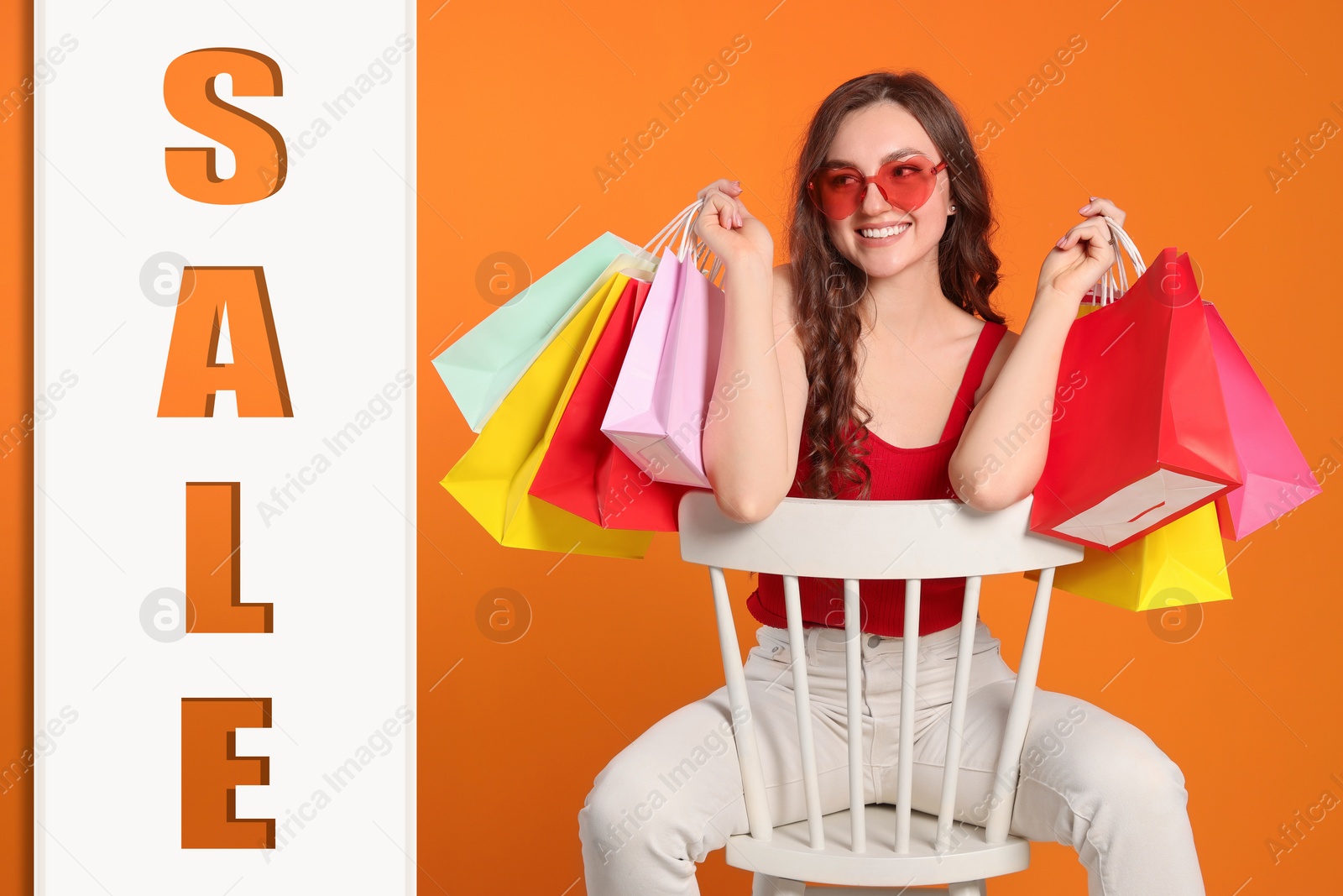 Image of Happy woman in stylish sunglasses with many colorful shopping bags and word Sale on against orange background