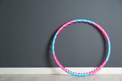 Photo of Hula hoop near grey wall in gym. Space for text