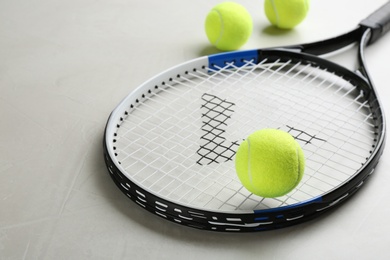 Photo of Tennis racket and balls on grey table. Sports equipment