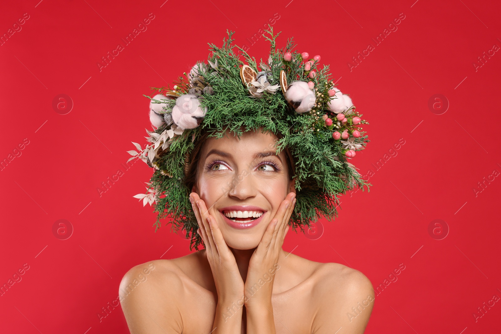 Photo of Happy young woman wearing wreath on red background