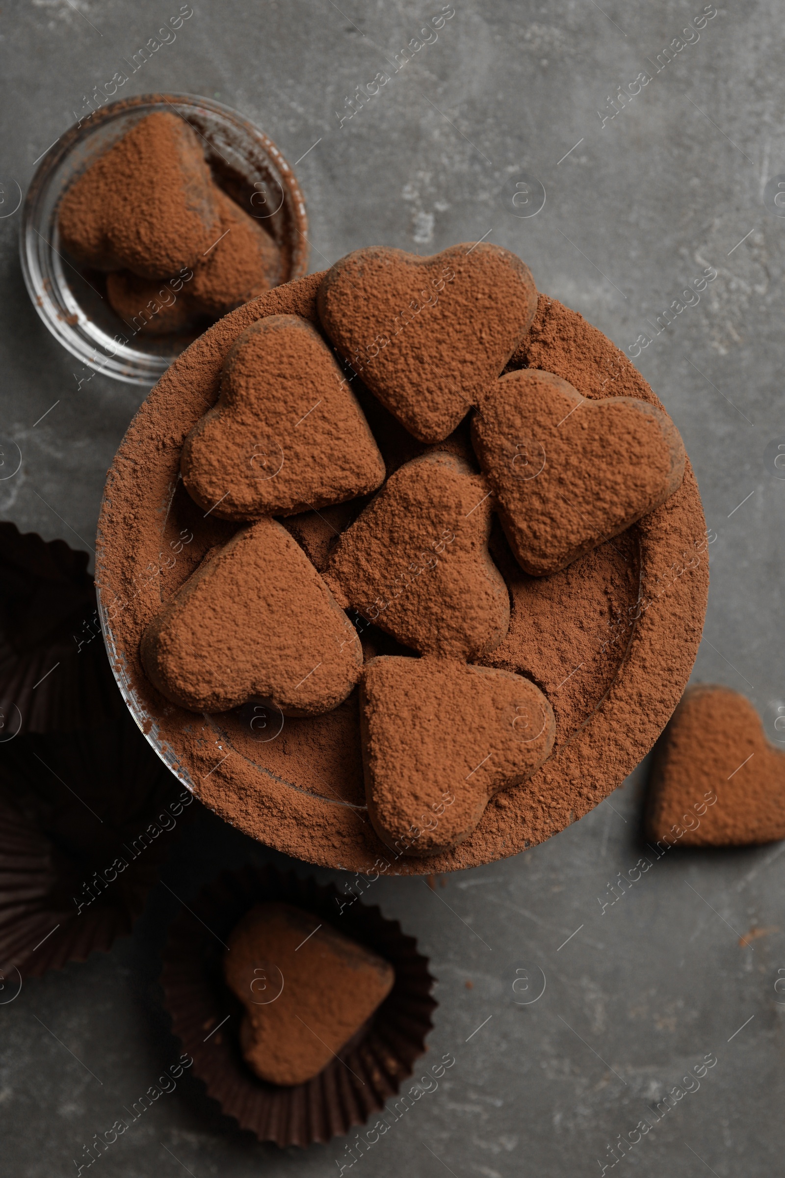 Photo of Delicious heart shaped chocolate candies on grey table, flat lay