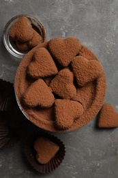 Photo of Delicious heart shaped chocolate candies on grey table, flat lay