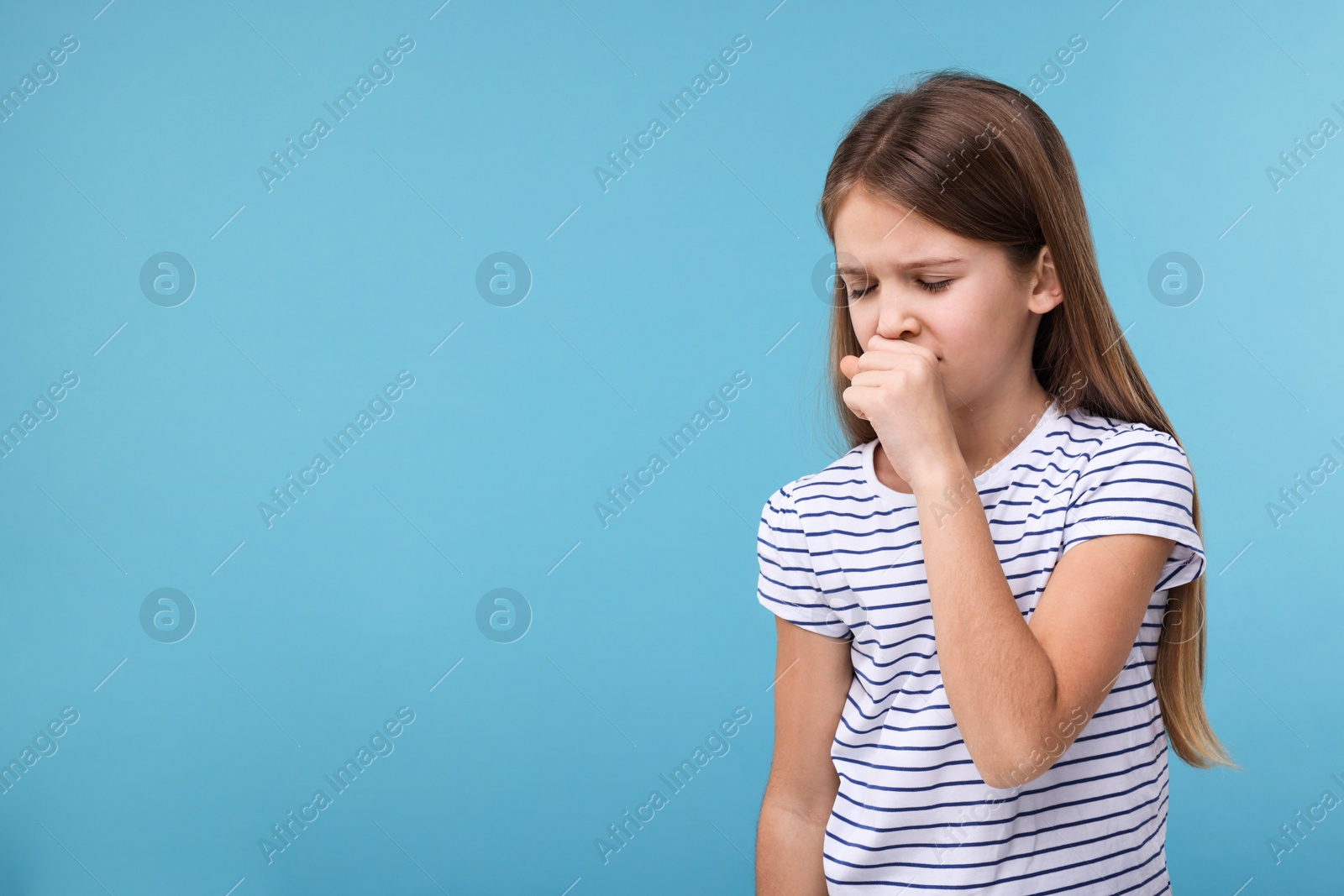 Photo of Sick girl coughing on light blue background, space for text