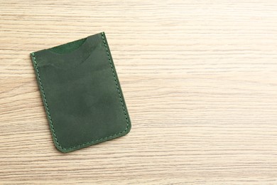 Photo of Leather business card holder on wooden table, top view. Space for text