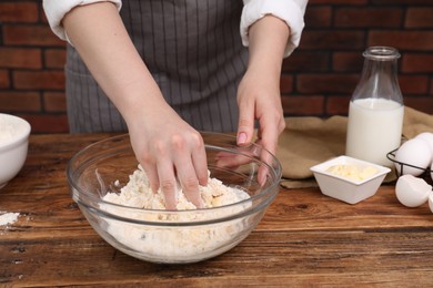 Preparing tasty baklava. Woman making dough at wooden table, closeup