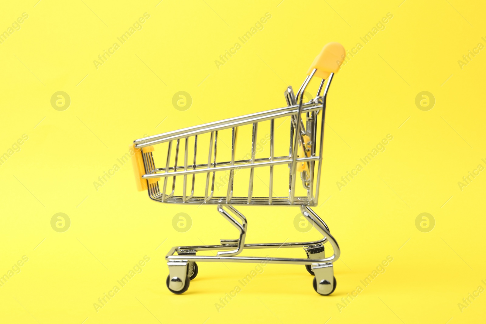 Photo of Empty shopping trolley with handle on color background