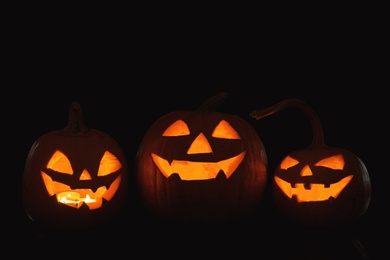 Photo of Halloween pumpkin heads. Glowing jack lanterns in dark