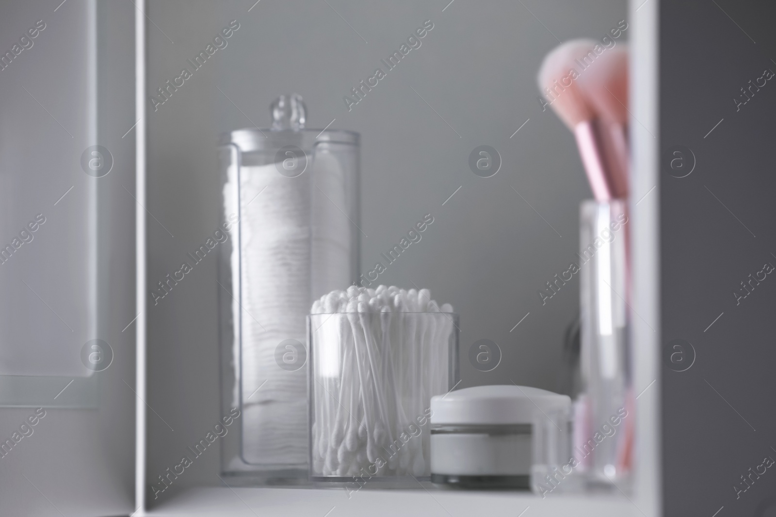 Photo of Cotton buds, pads and cream on table