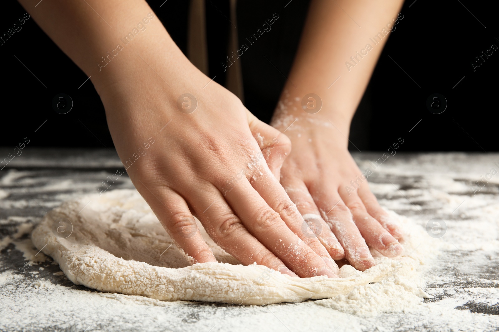 Photo of Woman kneading dough for pizza at grey table, closeup