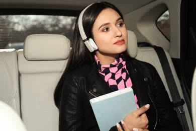 Photo of Young woman listening to audiobook in car